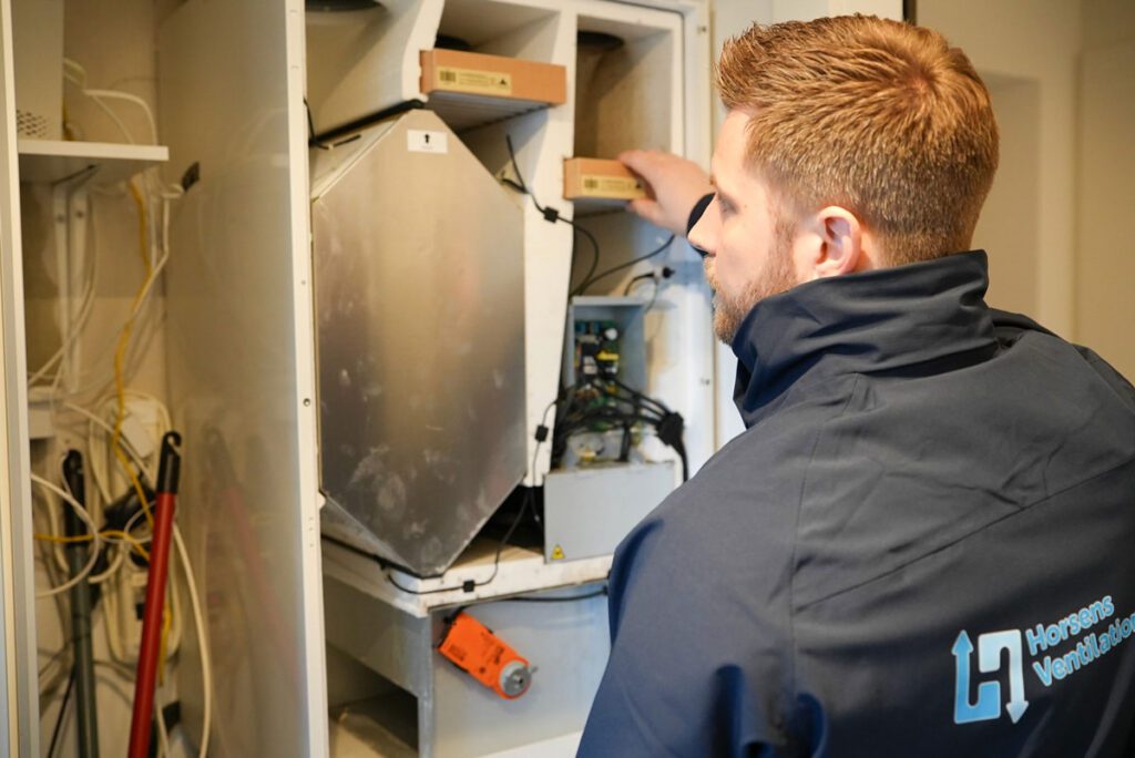 Medarbejder fra Jysk Ventilationsservice i gang med at udføre service på ventilationsanlæg hvor han også skifter filtrene