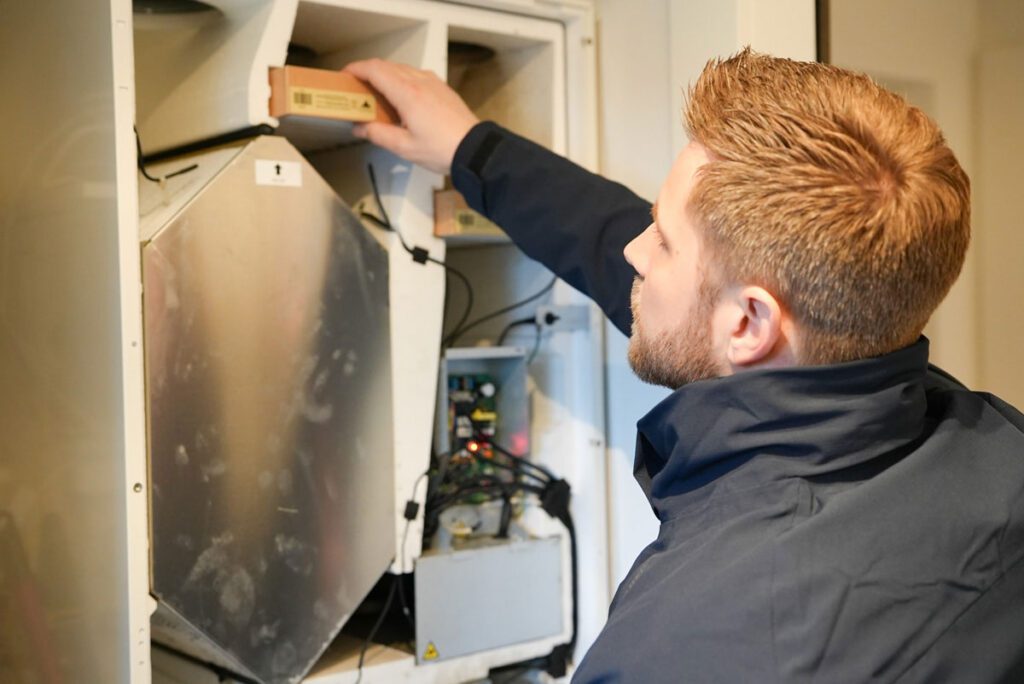 Medarbejder fra Jysk Ventilationsservice i gang med at udføre service på ventilationsanlæg og skifte filtre