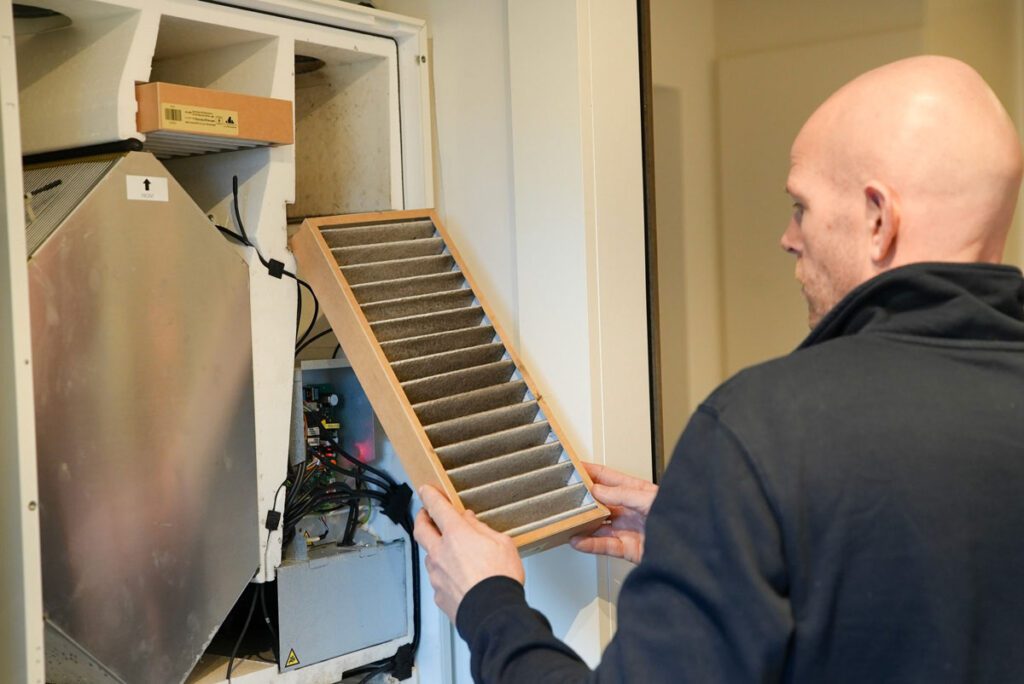 Ventilationsservice tekniker i gang med at skifte filter i et nyere ventilationsanlæg