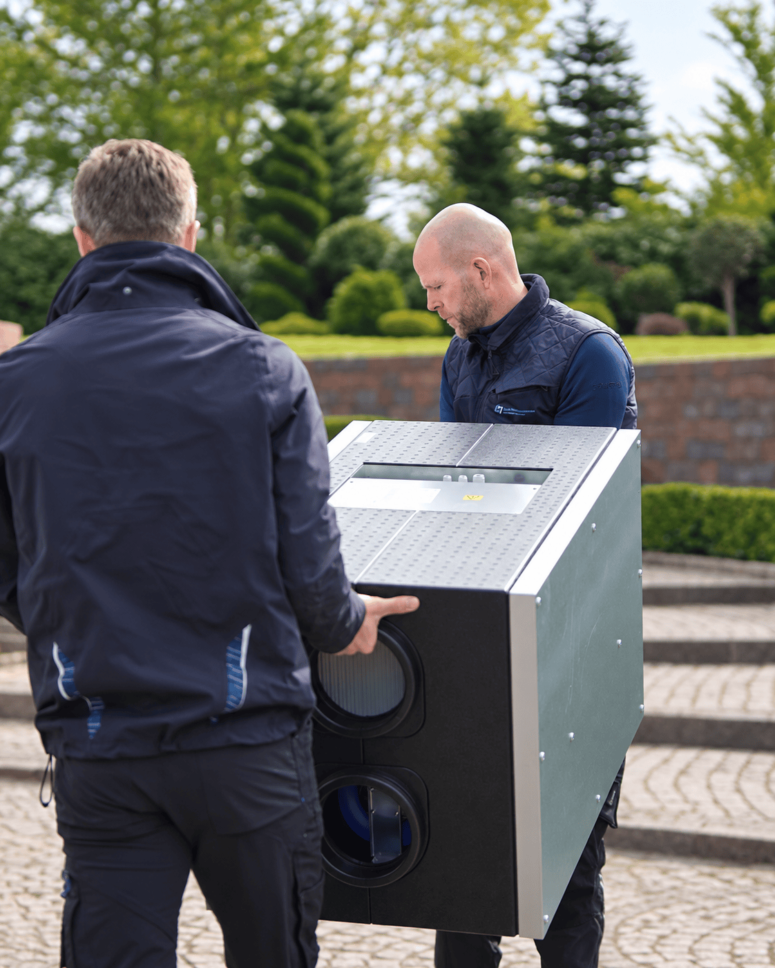 Vores teknikere bærer et nyt ventilationsanlæg ind til montering