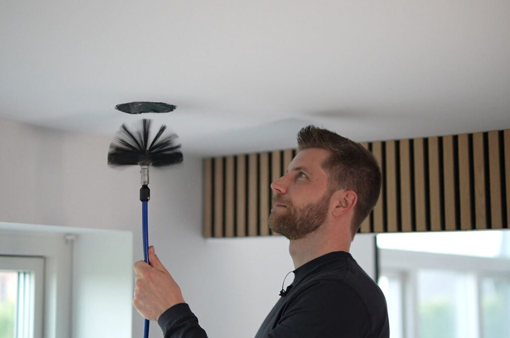 Professionel tekniker i gang med at rense et ventilationsanlæg i Fredericia.